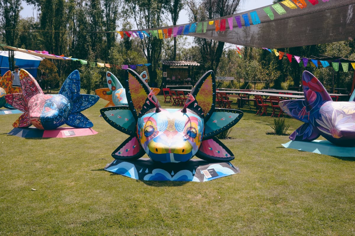 Painted axolotl sculptures beneath strings of papel picado