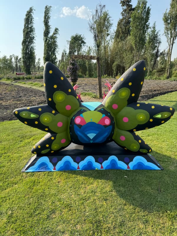 A dark green sculpture spotted with pink