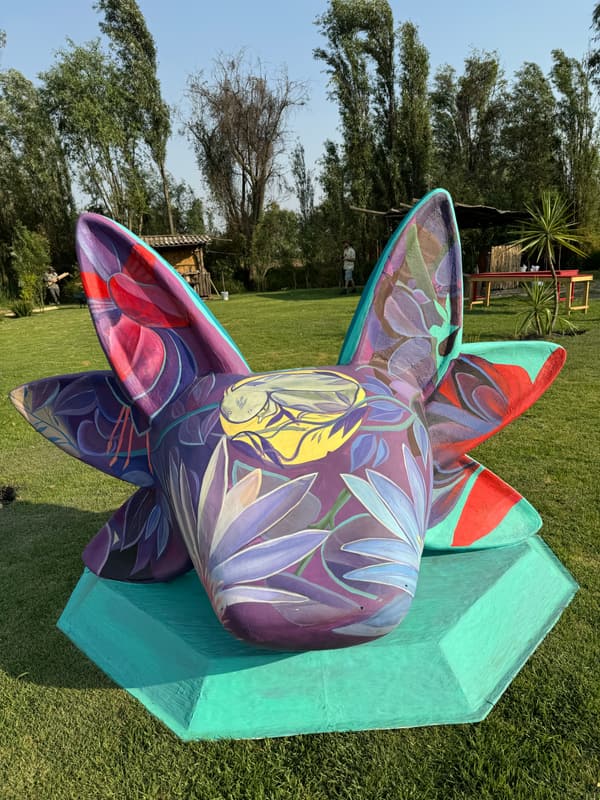 A lavender and pink sculpture on a teal plinth