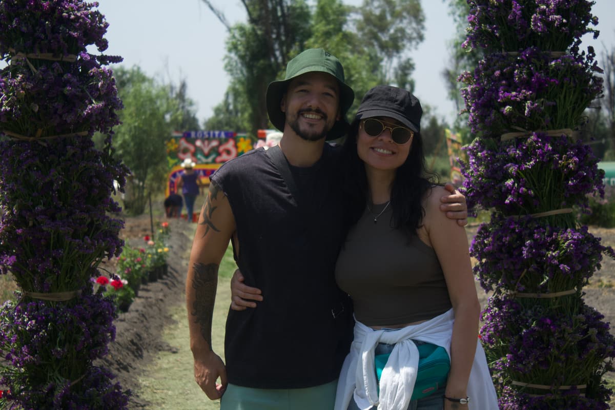 A couple posing between the flower columns