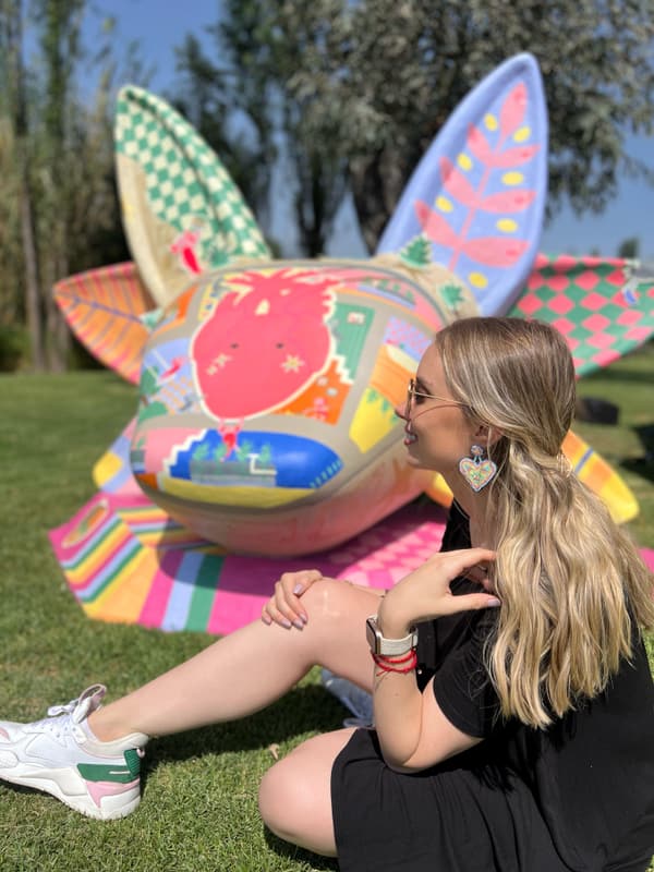 A visitor seated beside one of the painted sculptures