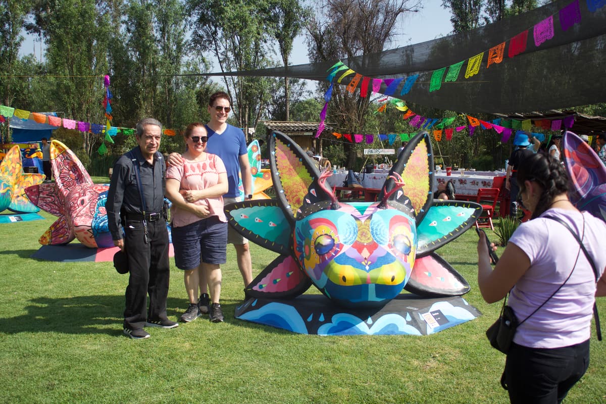 Visitors posing with a sculpture as a photographer shoots