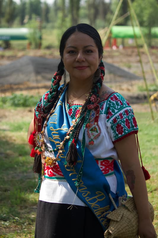 A woman in traditional dress with an embroidered sash