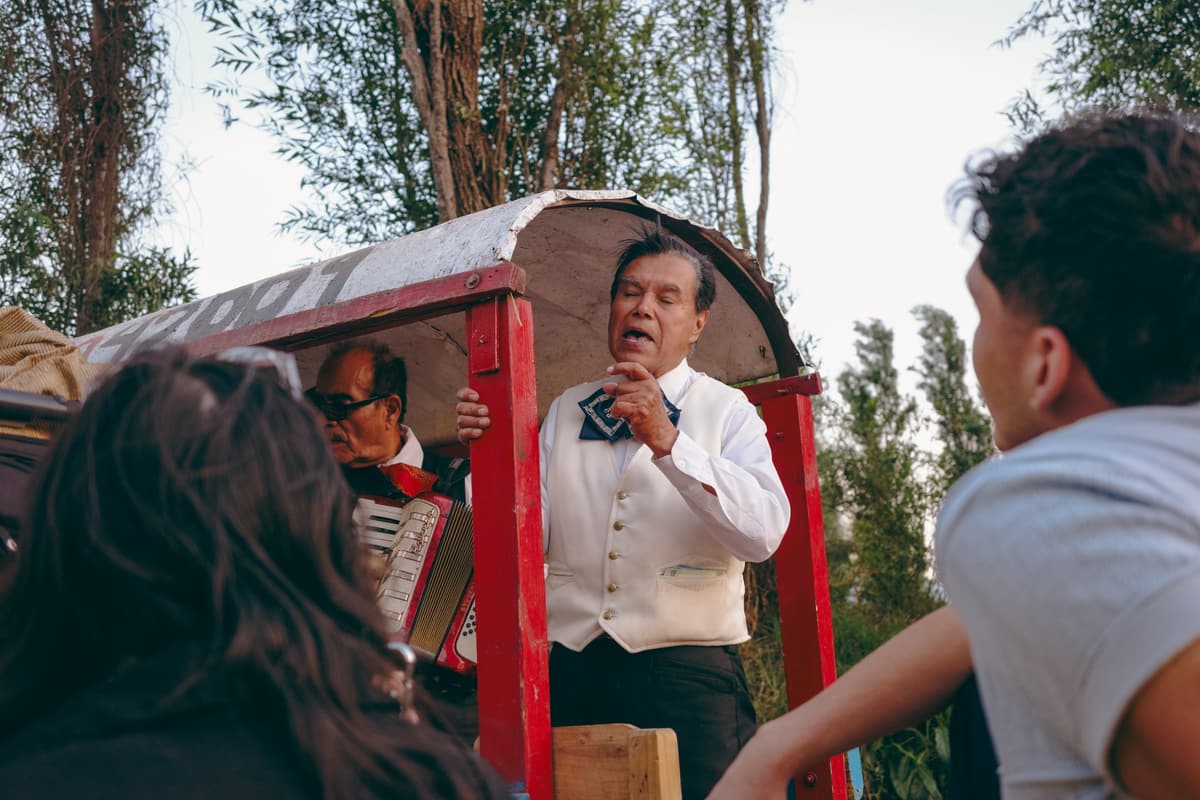 A singer performing for guests aboard a trajinera