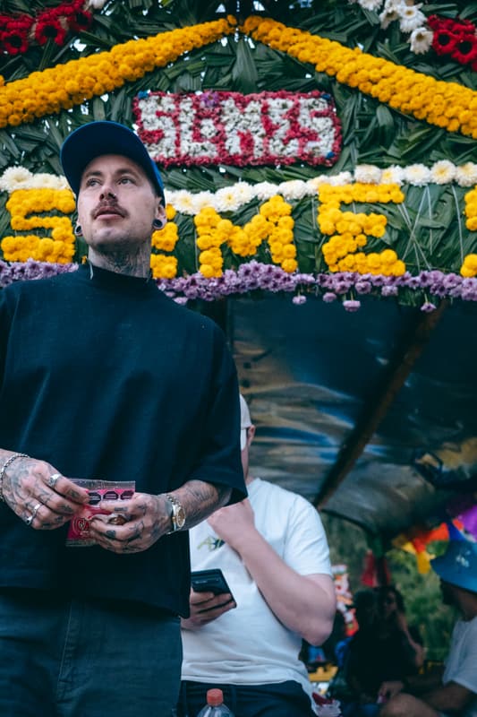 An attendee in front of the Somos flower arch