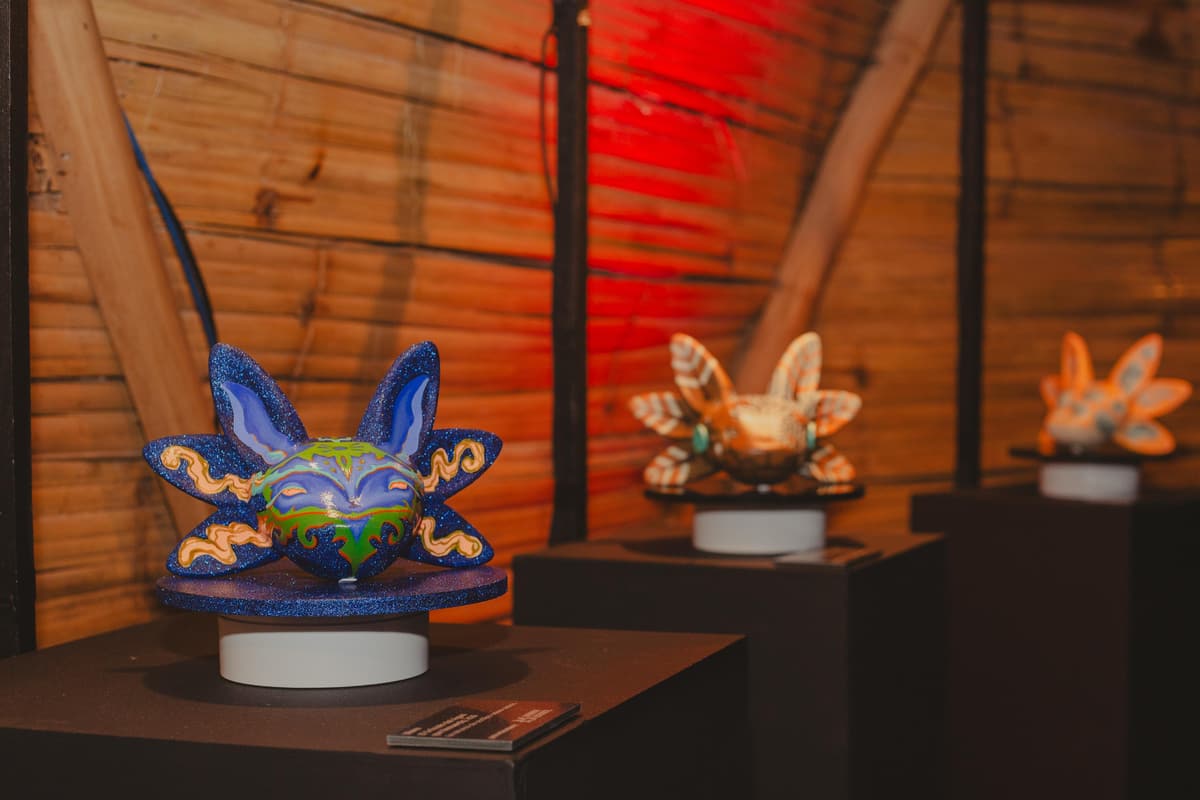 Two painted axolotl sculptures lit on their plinths