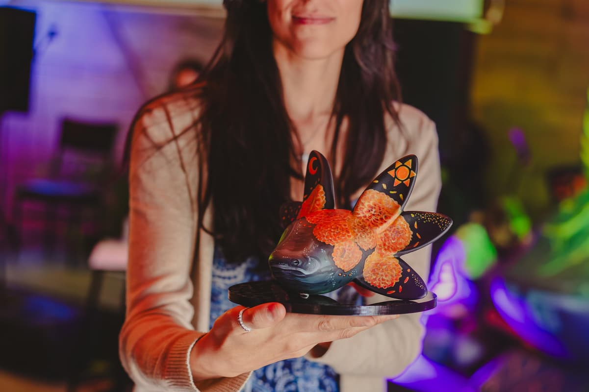 A guest holding a butterfly-painted sculpture