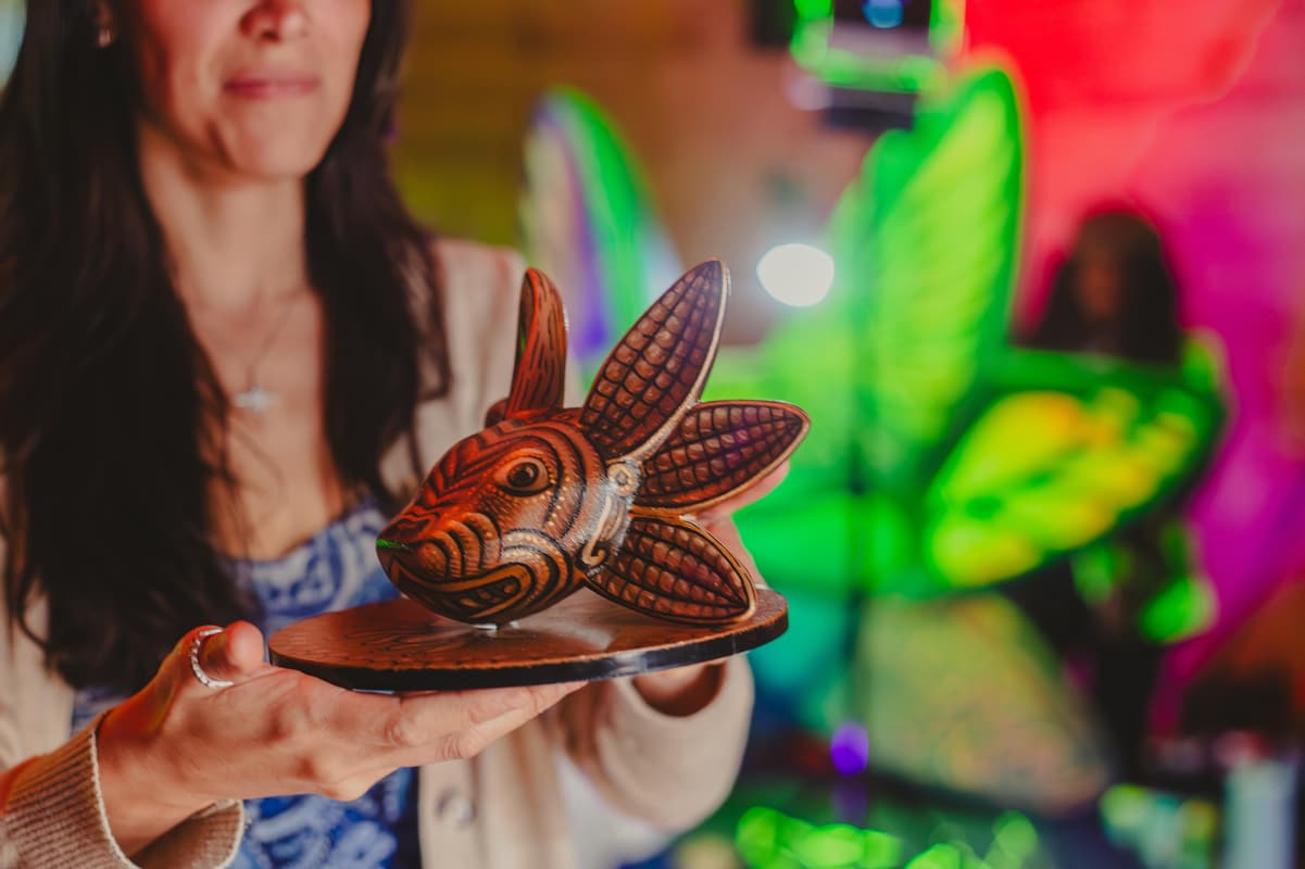 A guest holding a carved brown sculpture