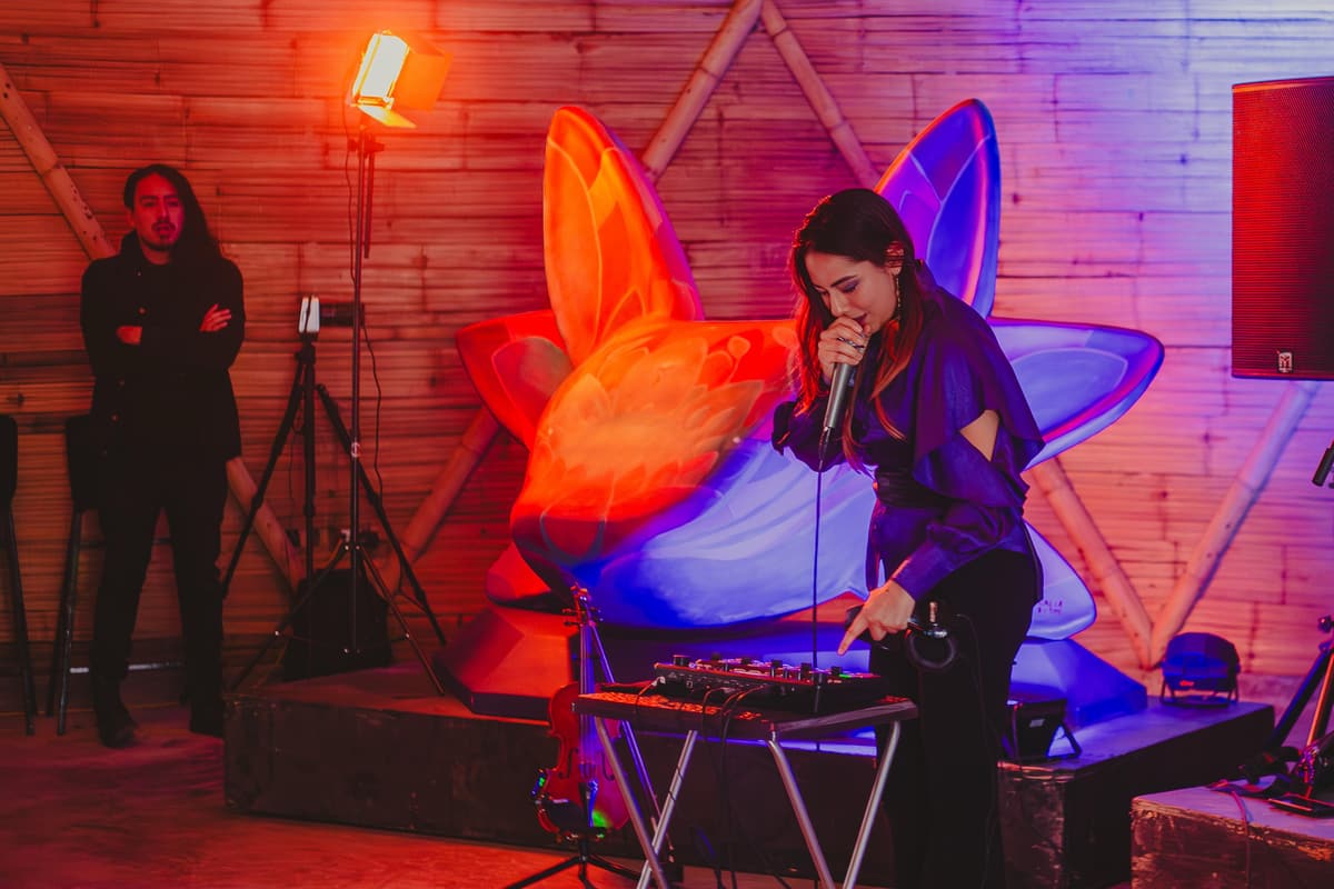 A DJ performing beside the sculptures