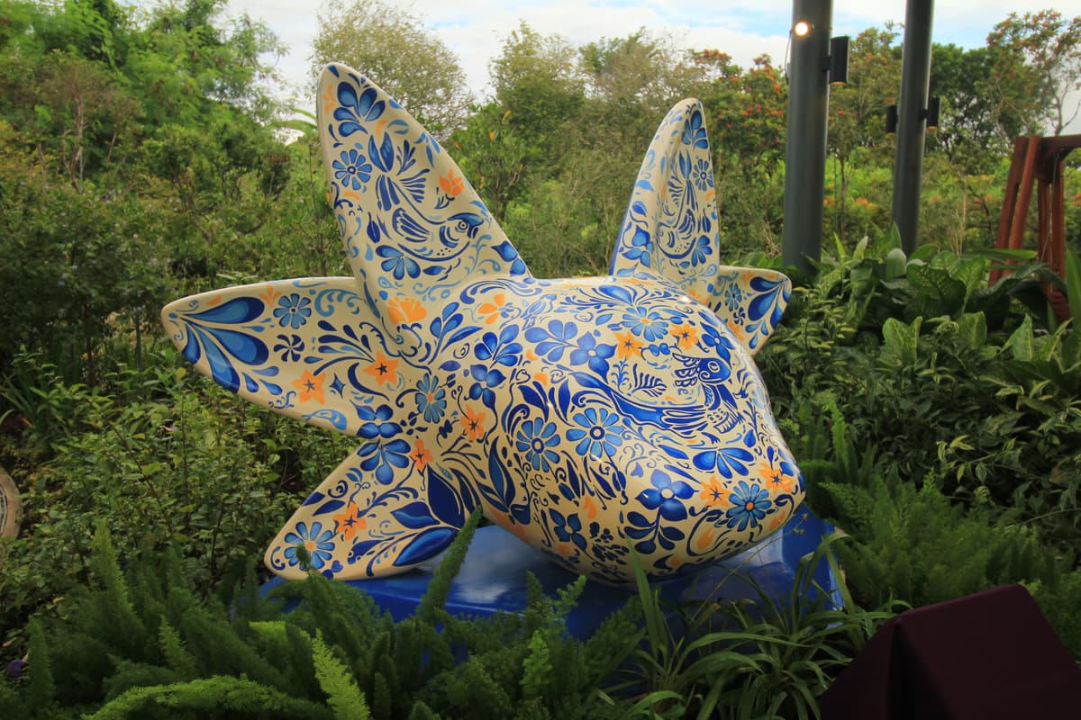 The blue-and-gold patterned axolotl sculpture seen head-on