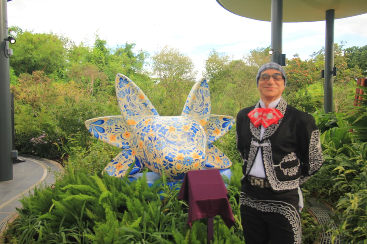 The mariachi standing with the sculpture before the ceremony