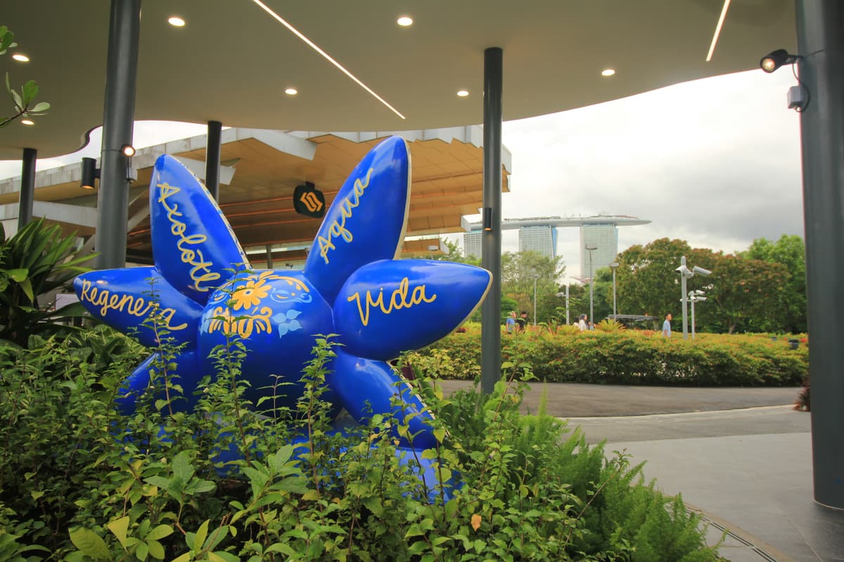 A second axolotl sculpture, painted deep blue with lettering