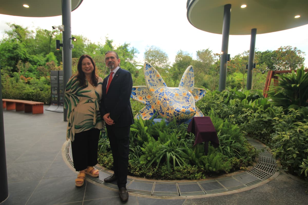 Two guests photographed beside the sculpture