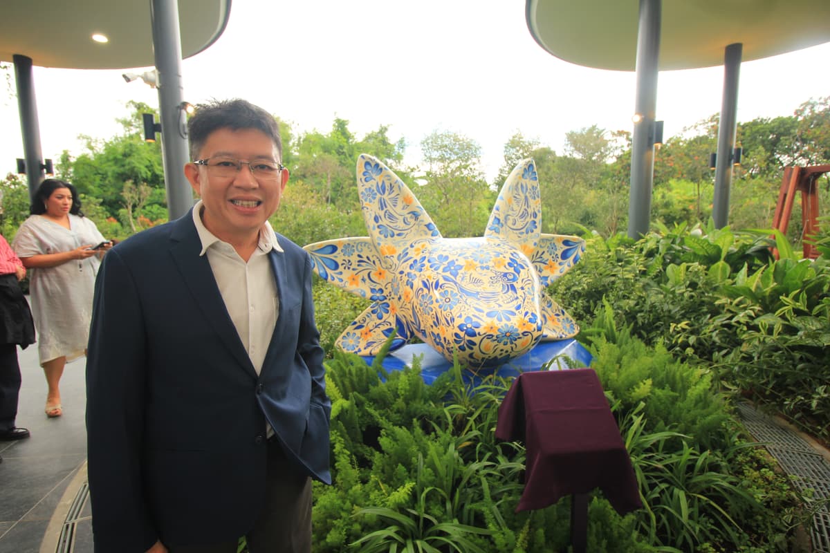 A guest posing with the sculpture