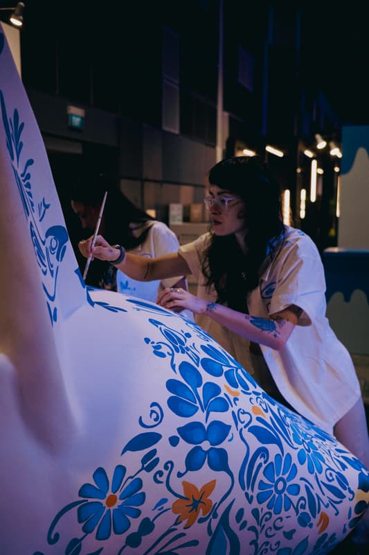 An artist painting one of the sculpture's fins