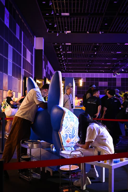 A wider view of the team painting in the exhibition hall