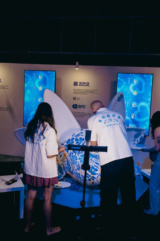A visitor beside the sculpture and the display screens