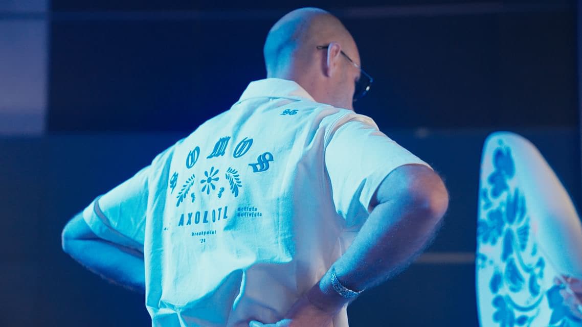 The Somos Axolotl jacket seen from behind, beside the sculpture