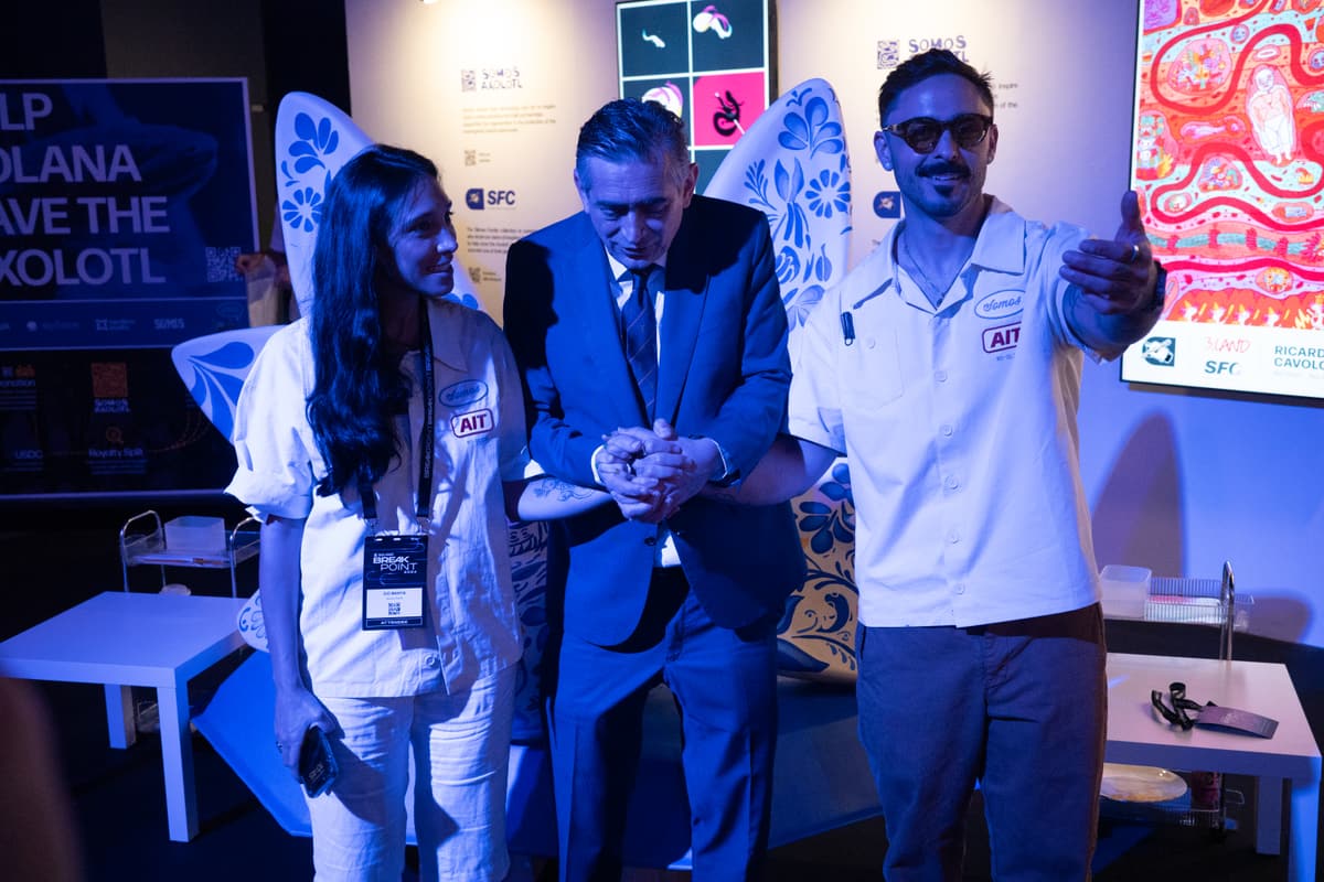 Three attendees in front of the axolotl display